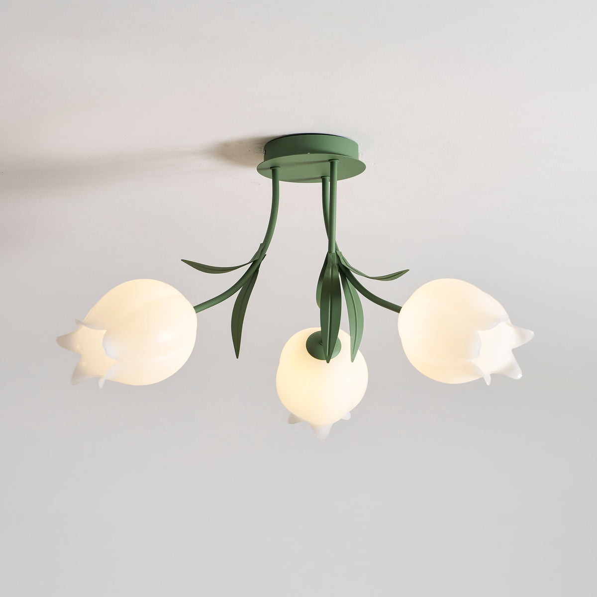 On a plain grey background, one shade of this Clérachic ceiling light in green shows a ruffled, irregular edge.