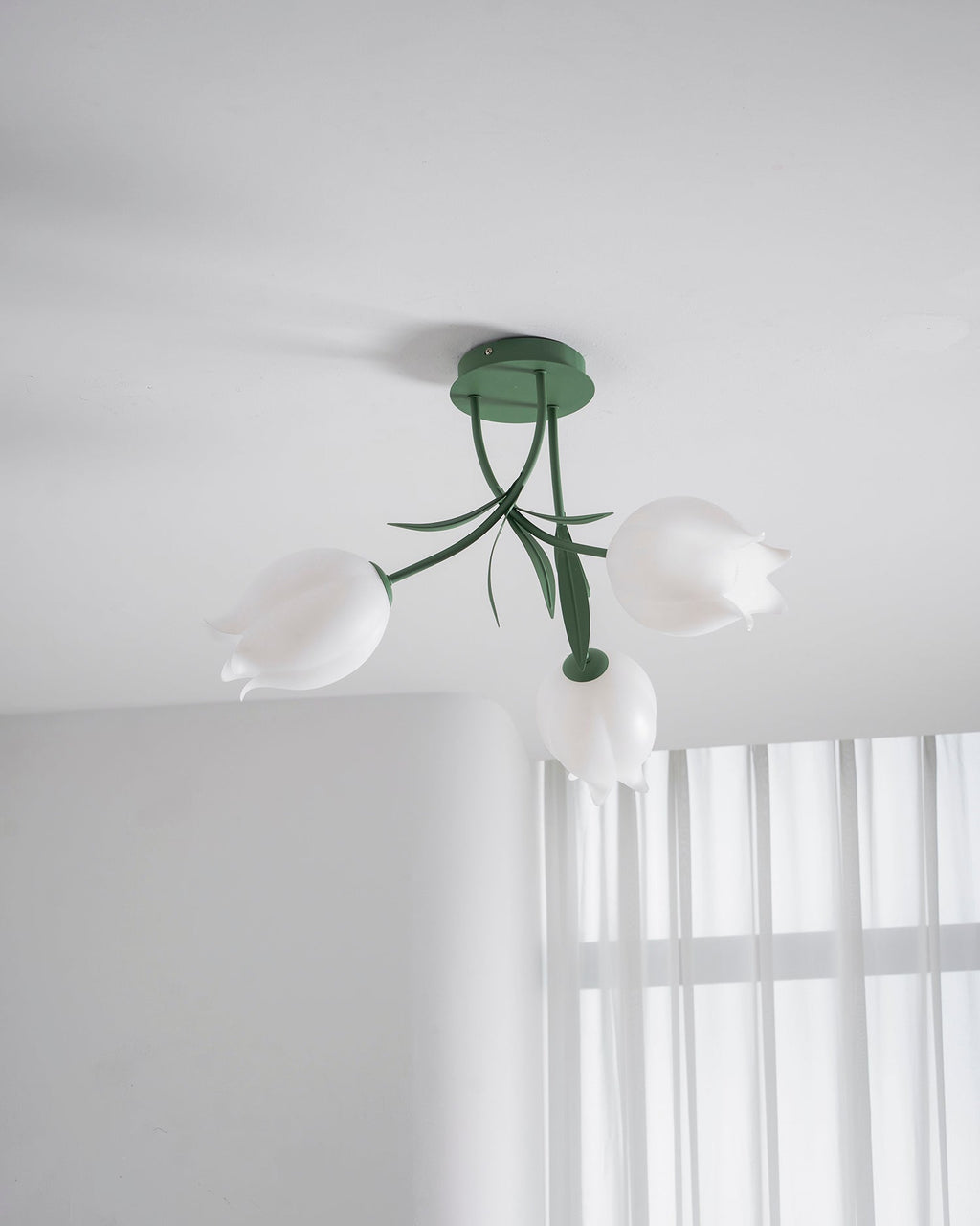 Near a bright, sheer-curtained window, this Clérachic ceiling light in green hangs in a minimally furnished room.