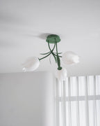 Near a bright, sheer-curtained window, this Clérachic ceiling light in green hangs in a minimally furnished room.