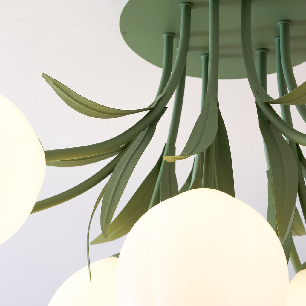 In dim light, the green stems and leaves of this Clérachic ceiling light fan downward with a few shades glowing softly.