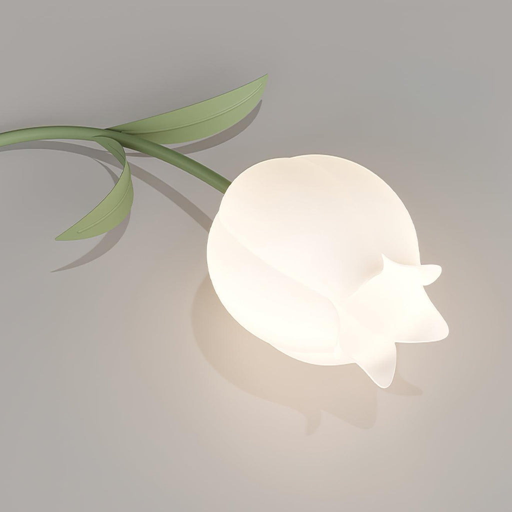 Close view of a single lily-shaped shade from this Clérachic ceiling light, its green leaf stem curling beside the acrylic petal.