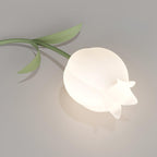 Close view of a single lily-shaped shade from this Clérachic ceiling light, its green leaf stem curling beside the acrylic petal.