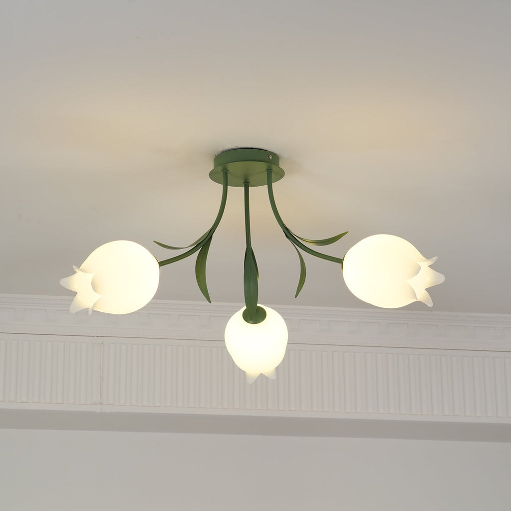 Beneath a decorative cove moulding, this Clérachic ceiling light in green hangs with its three shades unlit in daylight.