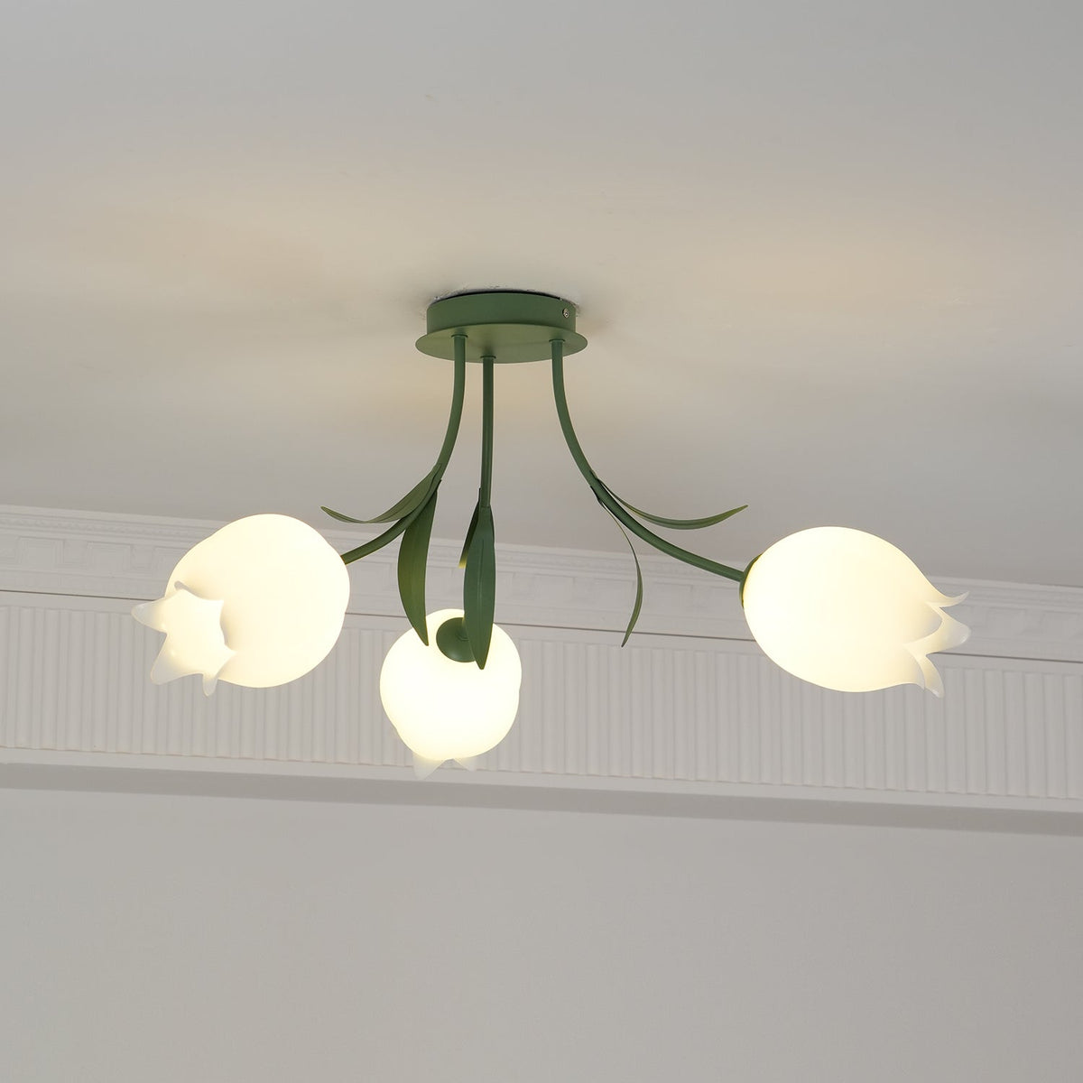 Near a cove moulding, this three-shade Clérachic ceiling light in green is seen from a slightly different angle.