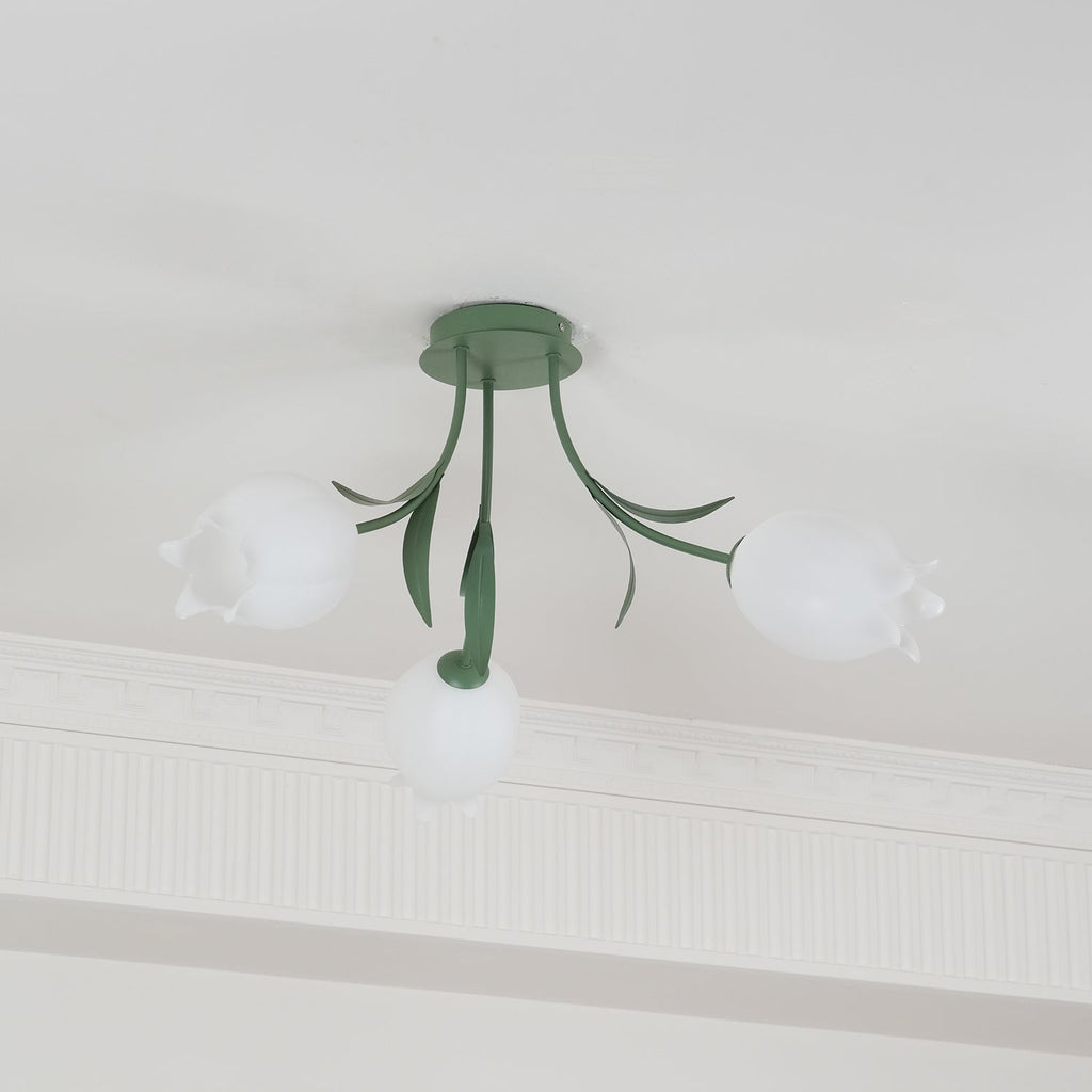 Beneath a cove moulding, this Clérachic ceiling light in green is mounted with its three shades unlit against a plain ceiling.