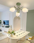 In a panelled room with an arched niche, this Clérachic ceiling light in green hangs above a small table set with tulips.