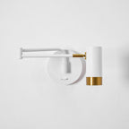 Black and gold swing arm wall lamp on a feature wall