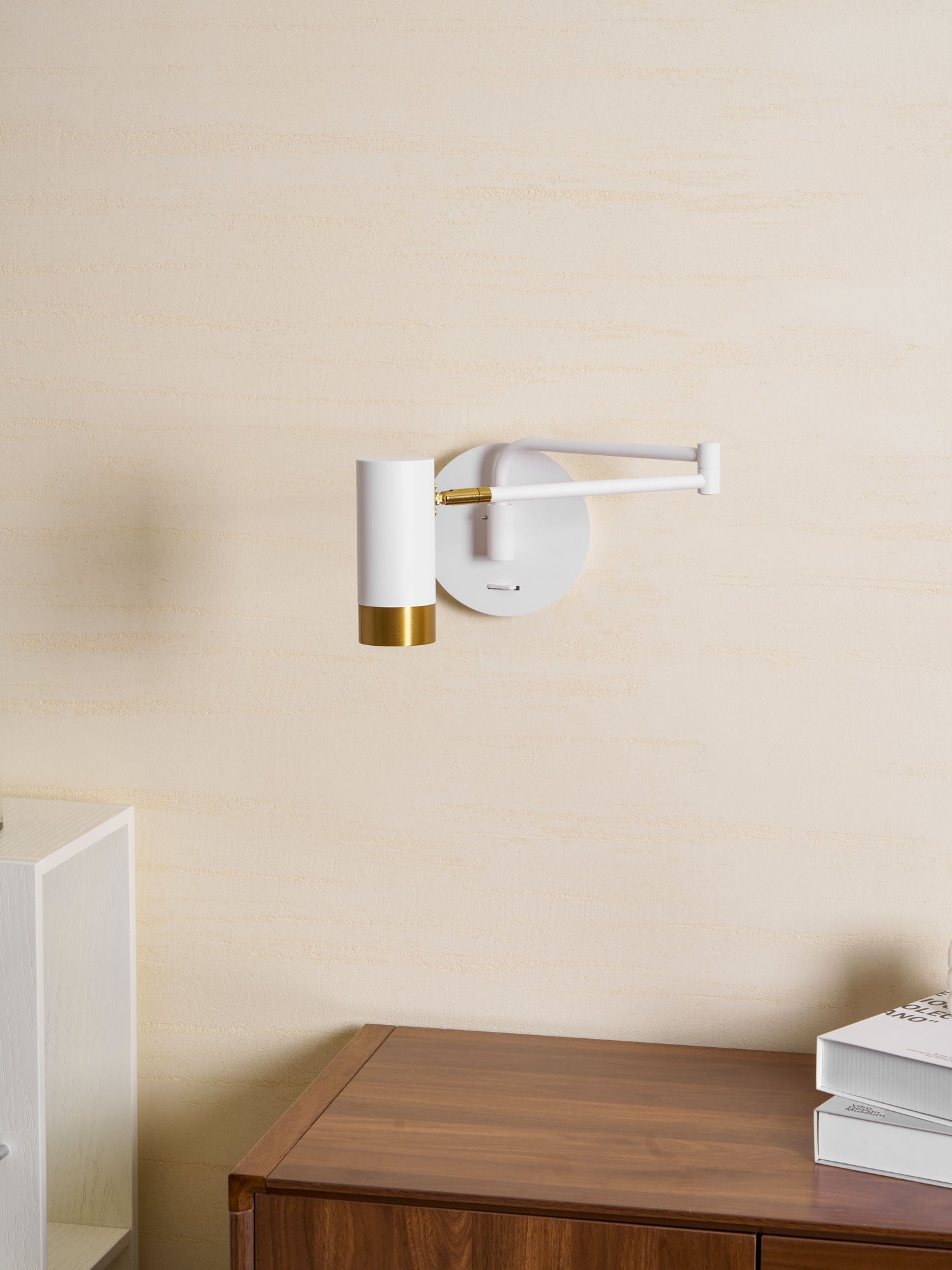 Swing arm wall lamp with shade swivelled to direct light