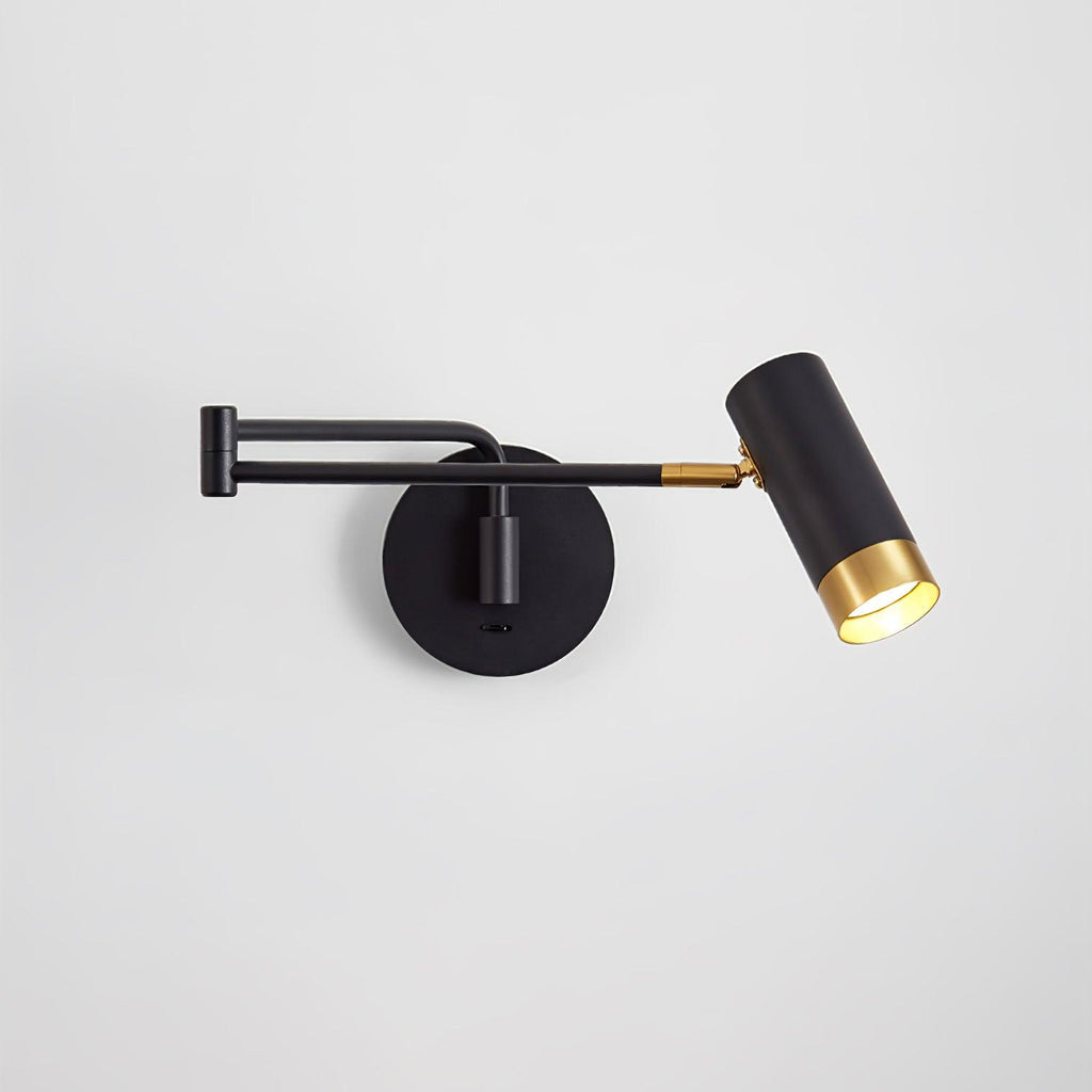 Swing arm wall lamp in white and gold beside a bed