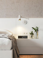 Black and gold swing arm wall lamp on a dark wall