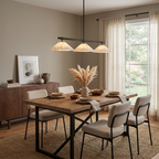 This Clérachic chandelier in matte black lights a rustic wood dining table with a walnut sideboard nearby.