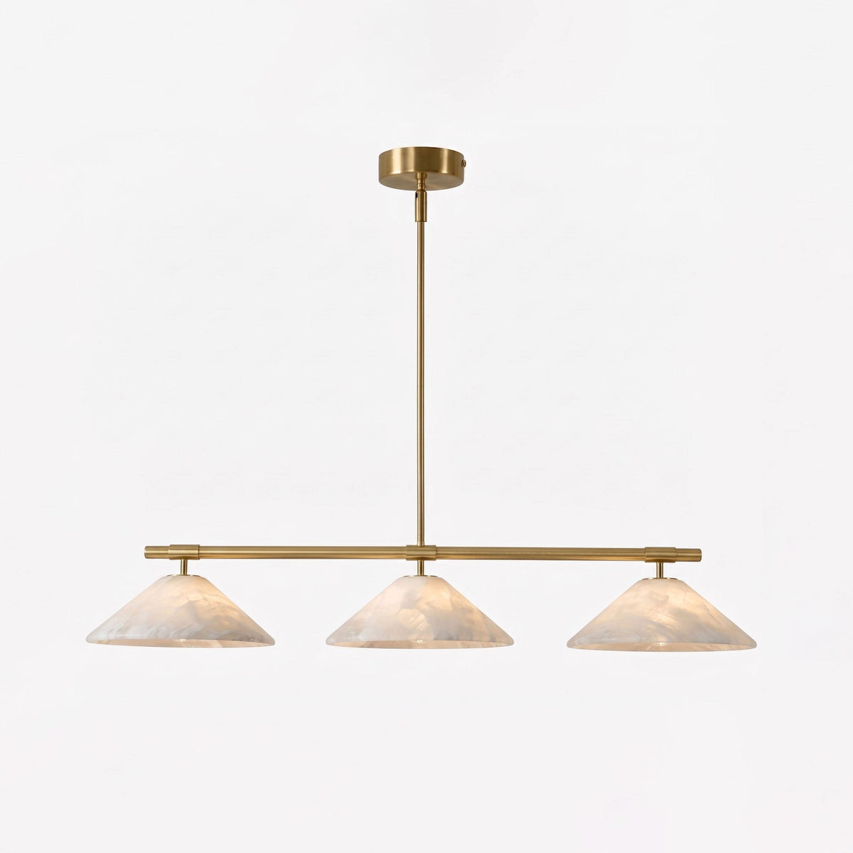 This lit Clérachic chandelier shows its brass stem and alabaster cone shades against a plain white backdrop.