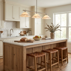 This Clérachic chandelier in brass lights a white kitchen island lined with tan leather stools.
