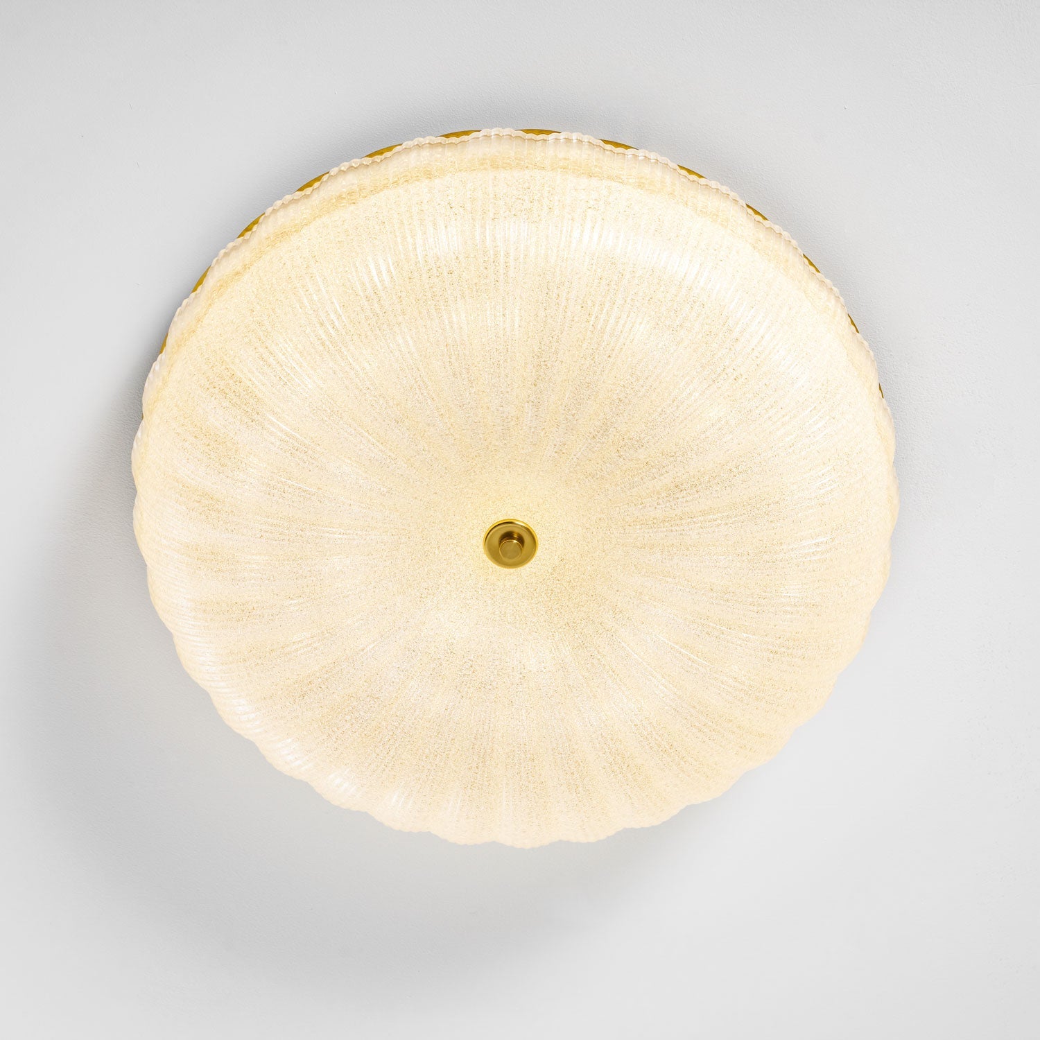 Frosted glass ceiling light detail with the gold rim visible
