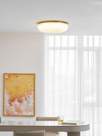 Gold-trimmed frosted glass ceiling light in a warm interior