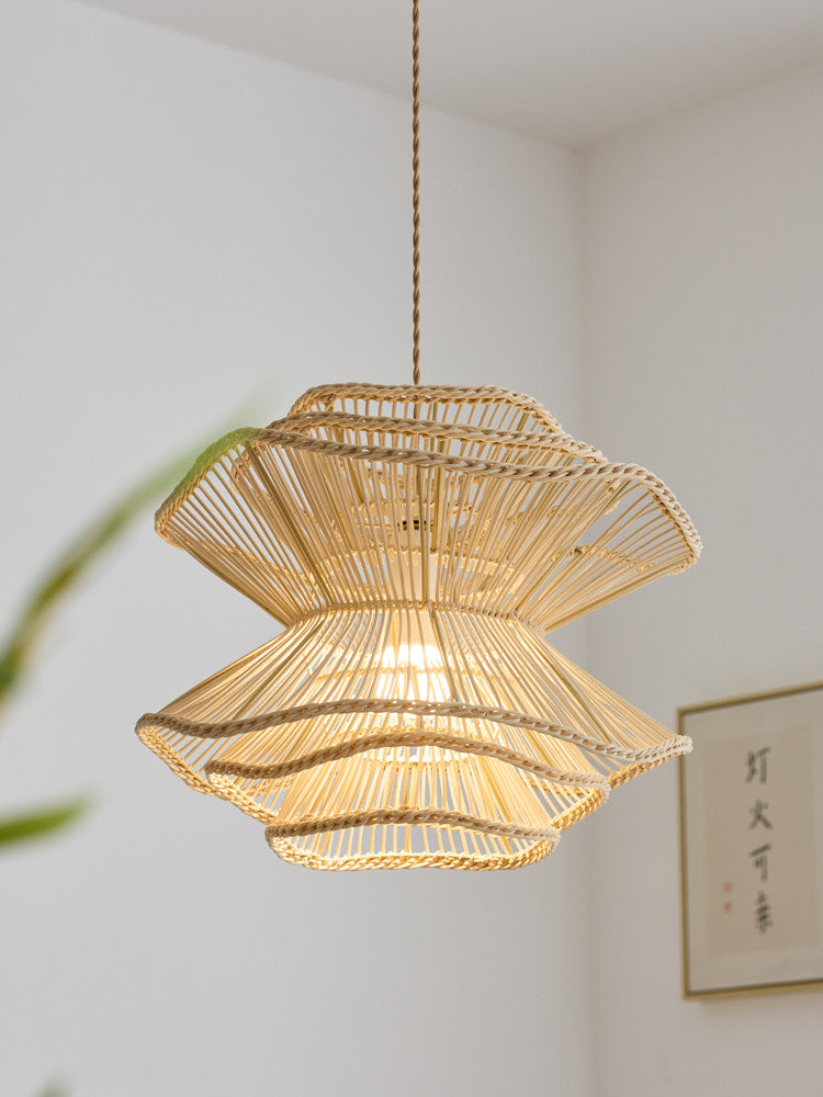 In close view near a wall print, this Clérachic pendant shows the woven texture of its narrow rattan waist.