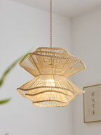 In close view near a wall print, this Clérachic pendant shows the woven texture of its narrow rattan waist.