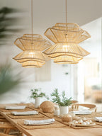 Two of this Clérachic pendant hang above a table styled with woven placemats and small sculptural objects.