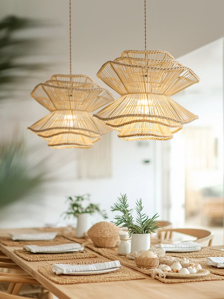 Two of this Clérachic pendant hang above a table styled with woven placemats and small sculptural objects.