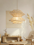 Near a rattan chair and a low wood table, this Clérachic pendant lights a room styled with pampas grass and a stone stool.