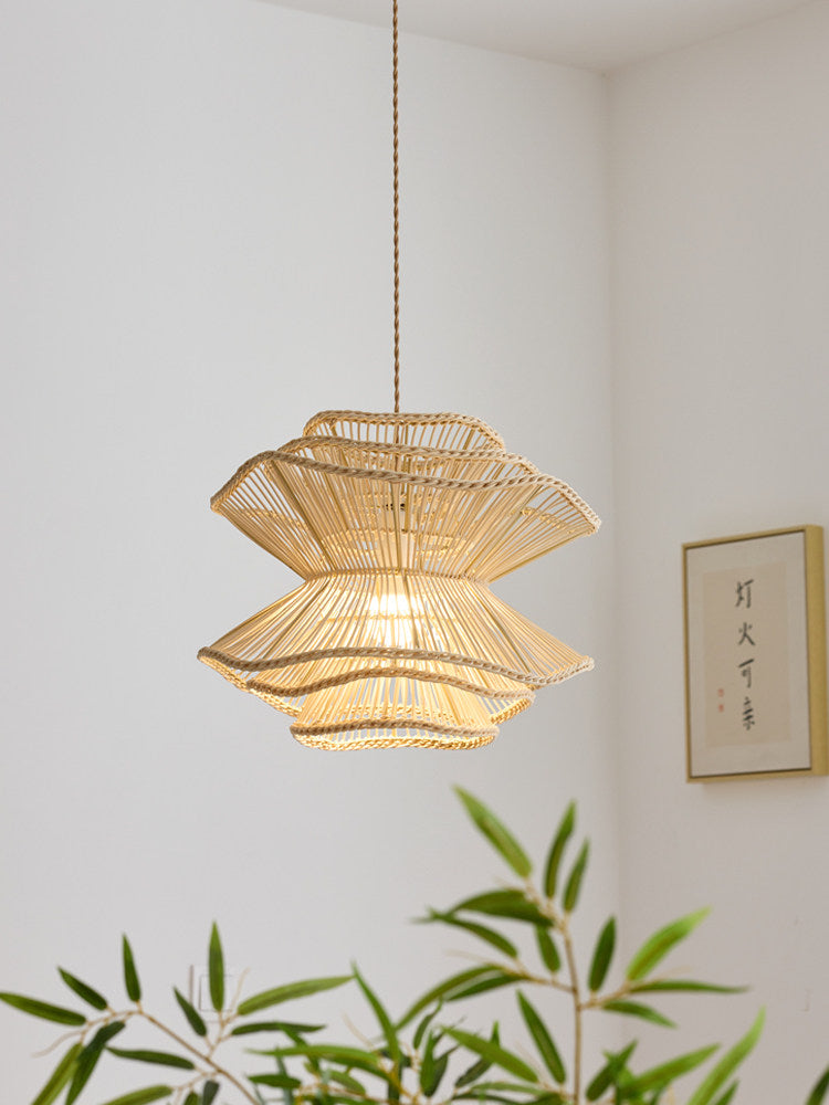 Framed by trailing green leaves, this Clérachic pendant hangs near a wall print in a plain, sunlit room.