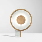 Straight-on close crop of the Clérachic disc lamp's lit ring and centre disc against a plain grey-white background.