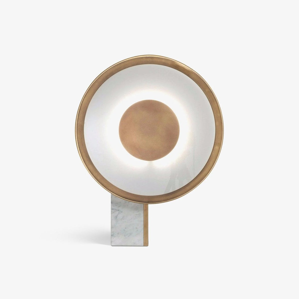 Clérachic gold disc table lamp shown straight on, lit, its rectangular marble foot planted on a plain background.