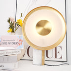 Clérachic lamp filling most of the frame beside flowers and stacked books, a line-art print and lettered card behind it.