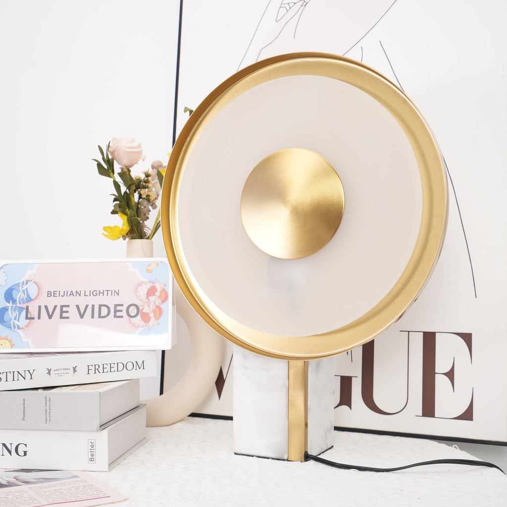The unlit Clérachic disc lamp shown close beside the same rose and stacked books, its frosted ring pale without the glow.
