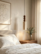 This Clérachic pendant glows beside sheer curtains, above a bed dressed beneath an abstract line-art print.