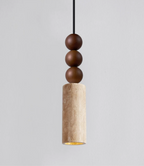 This Clérachic pendant's three stacked wood beads sit above a travertine cylinder, shown closely against white.