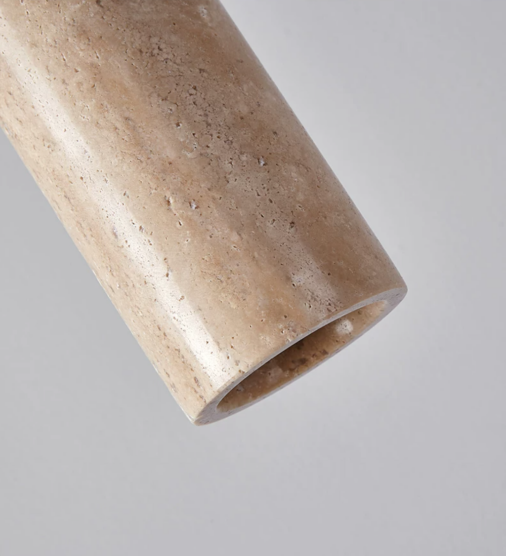 Close angled view of the travertine texture on this Clérachic pendant's cylinder shade.