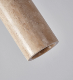 Close angled view of the travertine texture on this Clérachic pendant's cylinder shade.