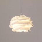 White floral rose pendant light glowing above a table