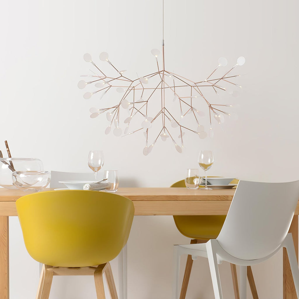 Rose gold firefly chandelier lit above a seating area