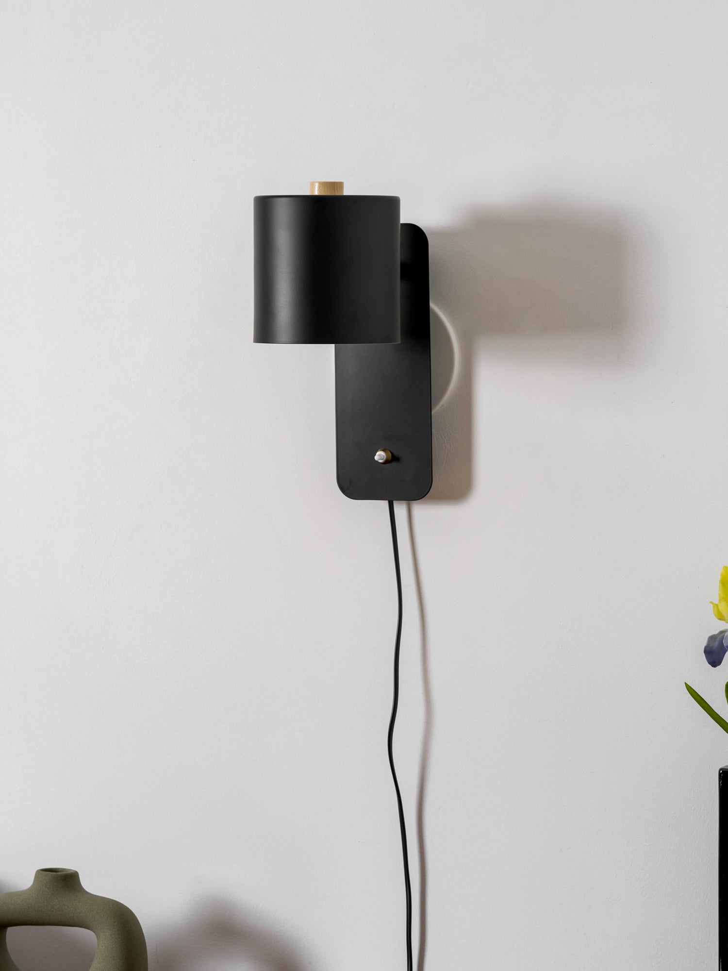 Cylinder wall lamp shown angled down for directed reading light