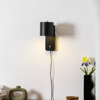 Metal cylinder wall lamp with soft glow in a styled living space