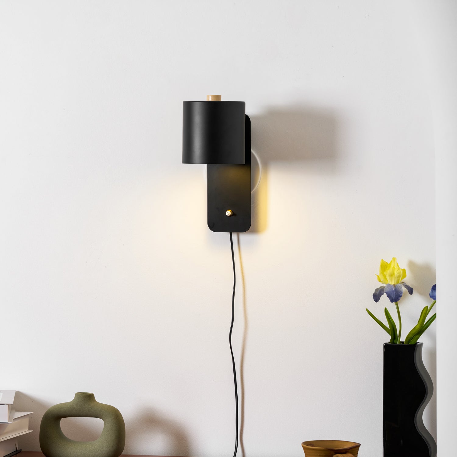 Metal cylinder wall lamp with soft glow in a styled living space