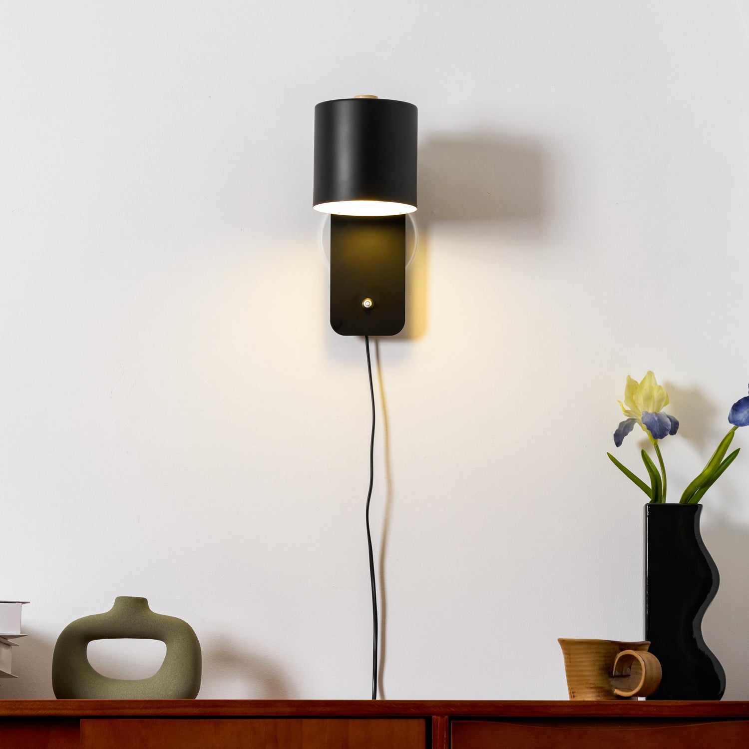 Rotatable cylinder wall lamp shown beside a framed wall print