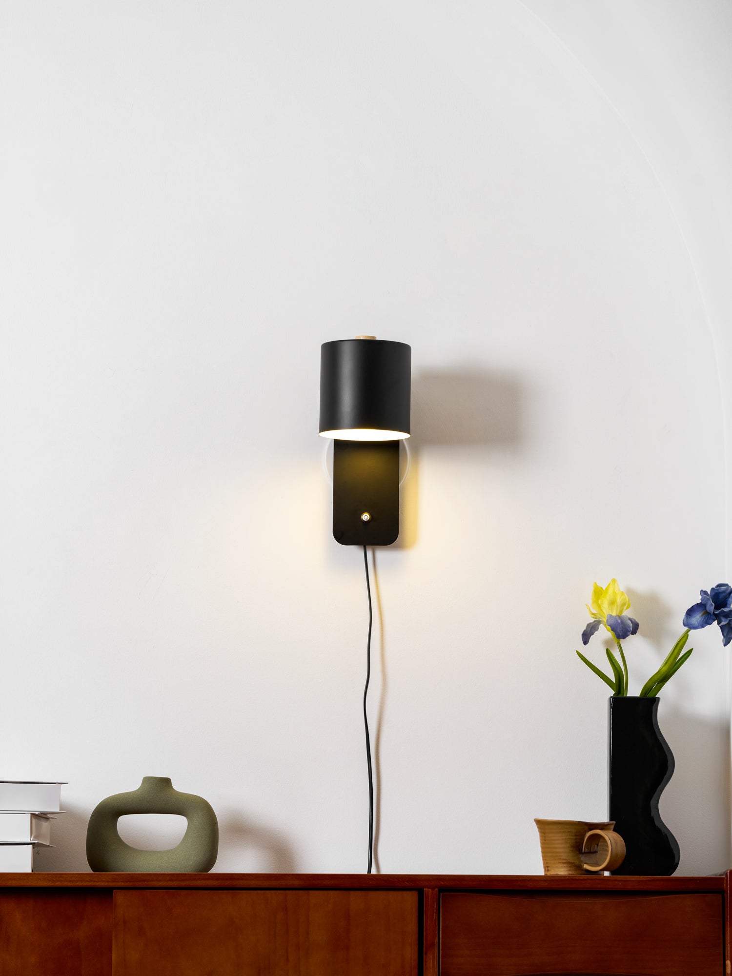 Metal cylinder wall lamp angled outward from the wall bracket