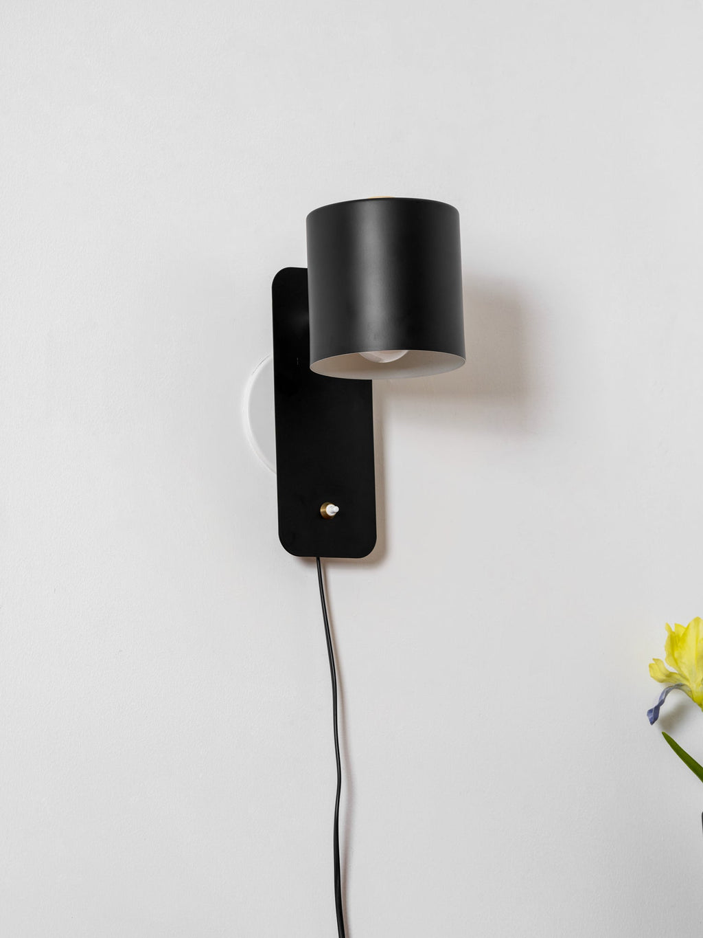 Cylinder wall lamp angled sideways showing the rotatable shade