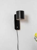 Cylinder wall lamp angled sideways showing the rotatable shade