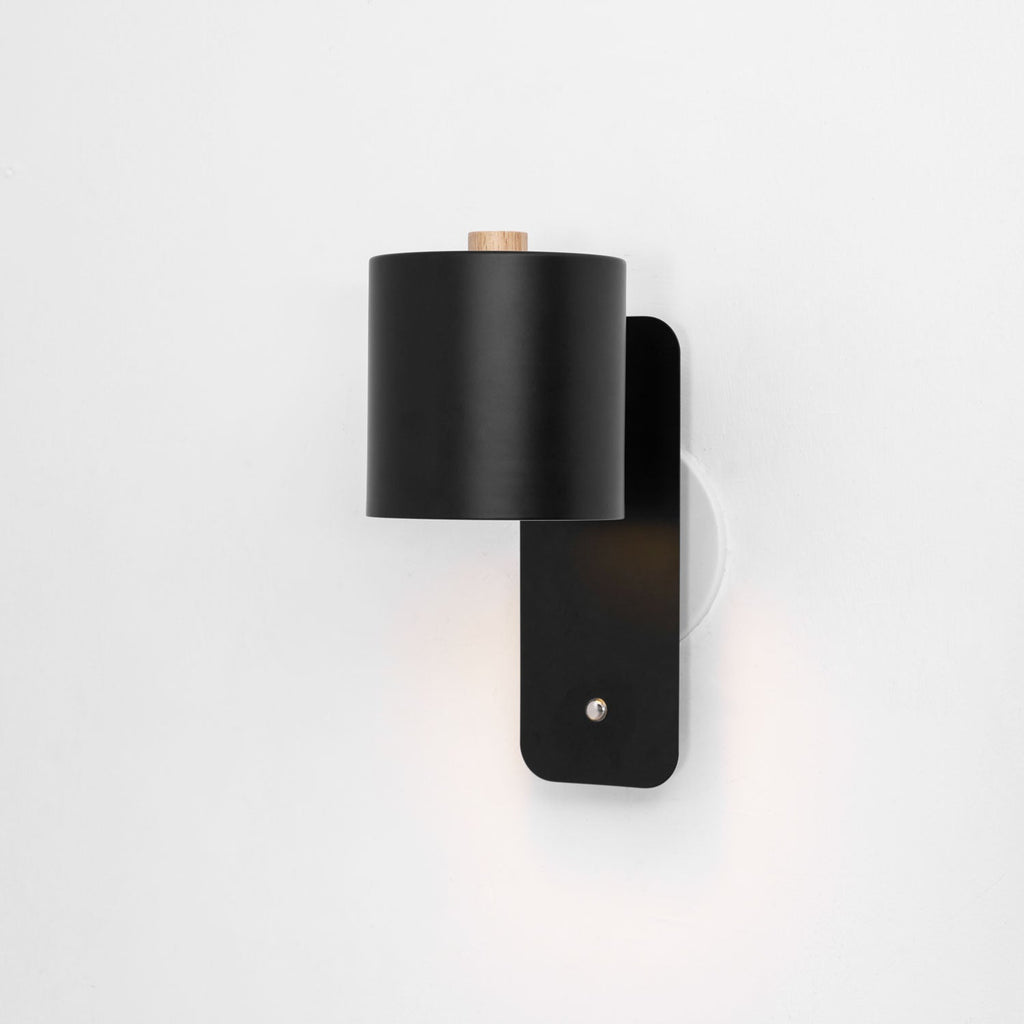 Cylinder wall lamp shade rotated to uplight the wall