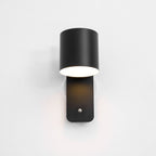Cordless cylinder wall lamp lit beside framed wall art
