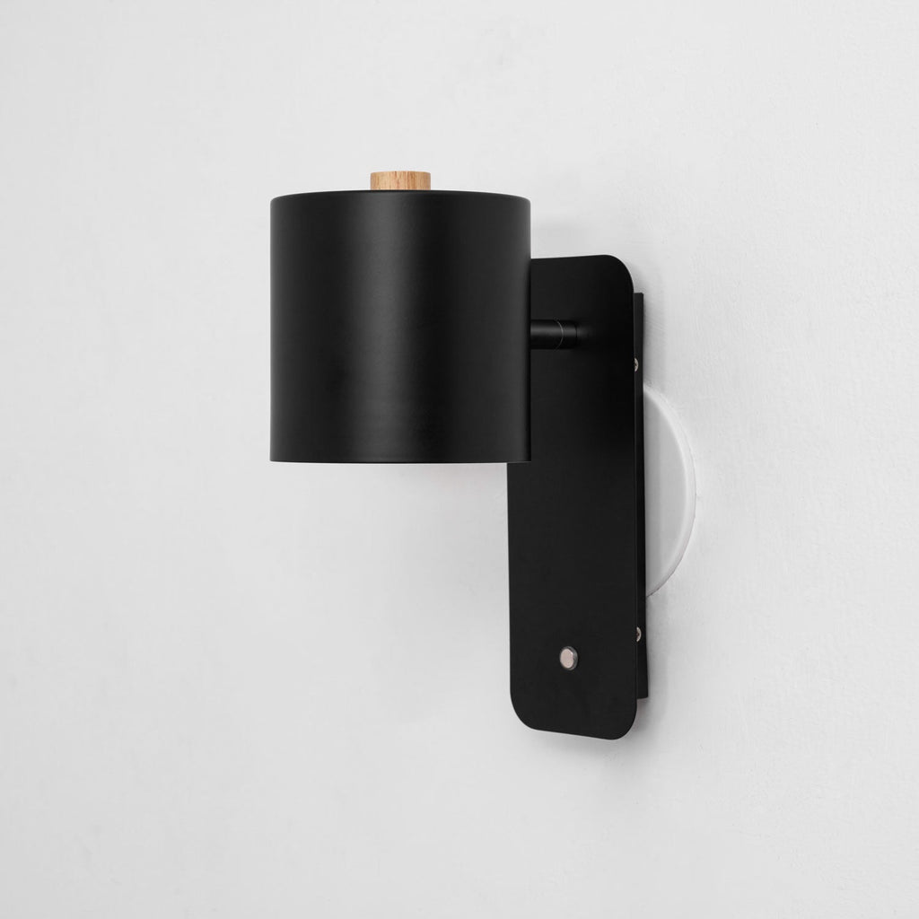 Cylinder wall lamp close-up showing brushed metal body