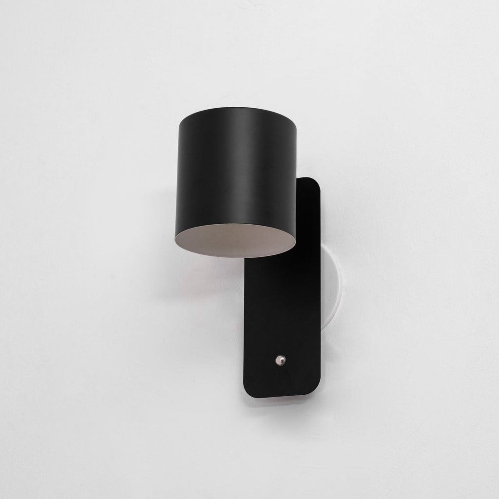 Cordless cylinder wall lamp on a hallway feature wall