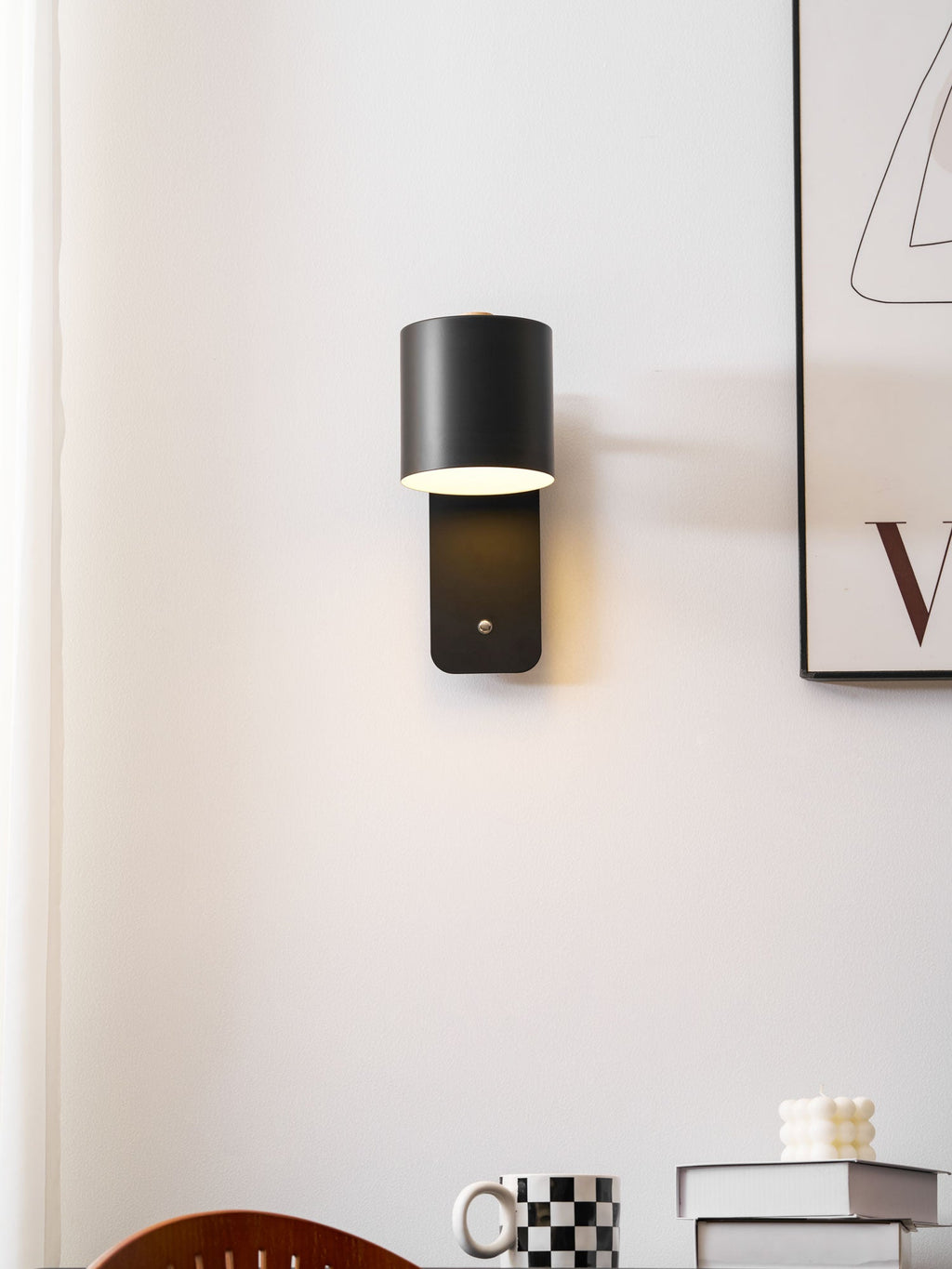 Cylinder wall lamp in grey casting warm ambient light