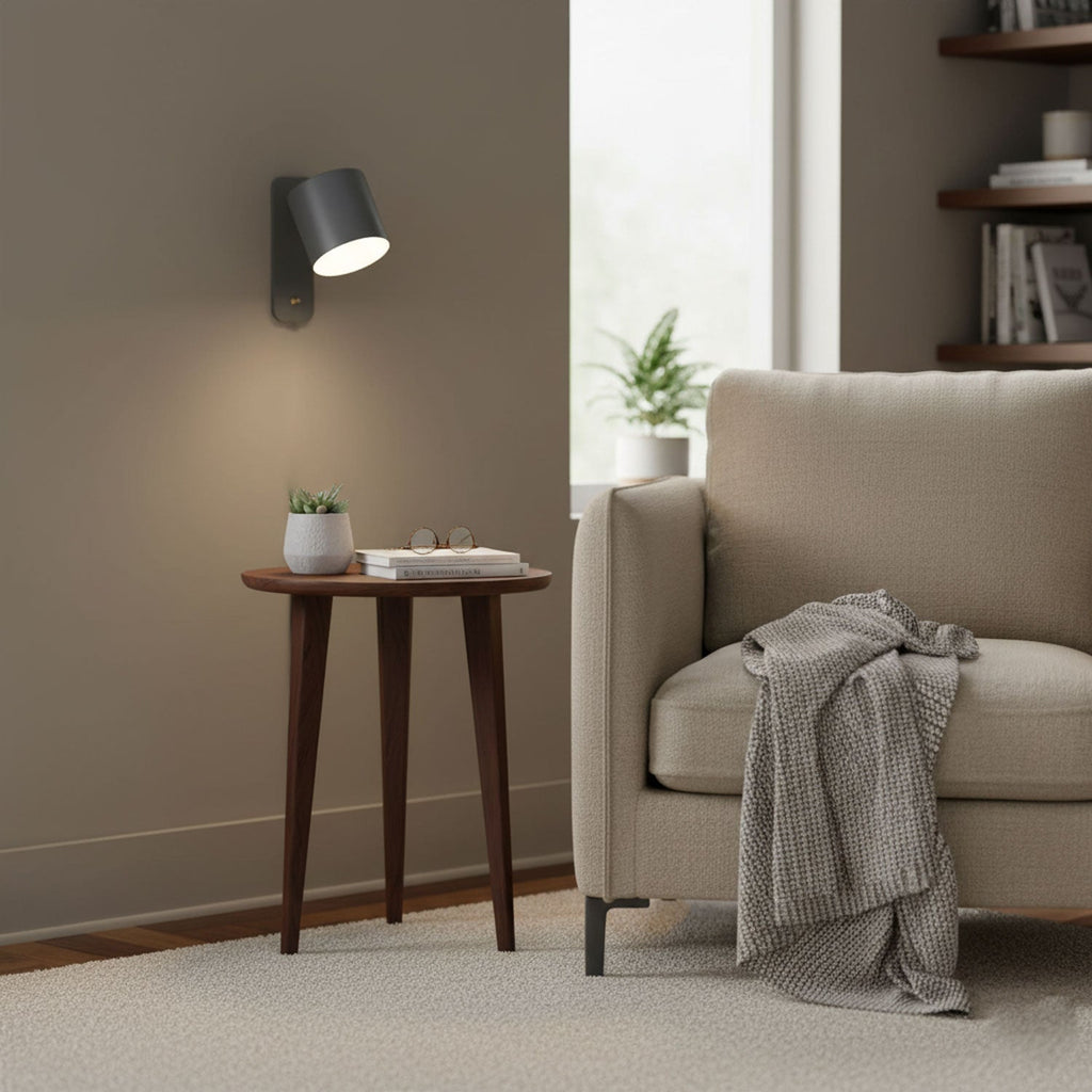 Rotating cylinder wall lamp beside a styled shelf