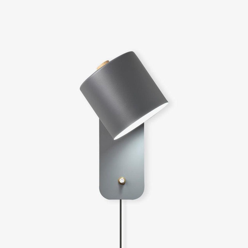 Minimalist metal cylinder wall lamp shown mounted on a wall