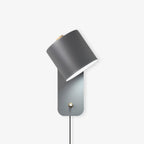 Minimalist metal cylinder wall lamp shown mounted on a wall